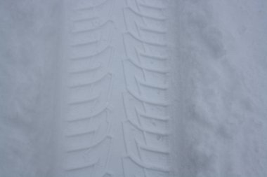 Beyaz pofuduk kar üzerinde geçen bir arabanın izi. Metin için arkaplan.