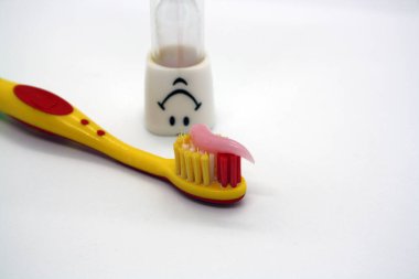 Yapıştırıcılı çocuk diş fırçası ve kum saati. Metin için boşluk.