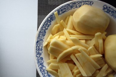 Soyulmuş patatesler pişmeye hazır. Mutfak geçmişi. Metin için boşluk.