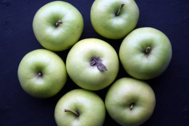 Siyah arka planda sulu sarı elmalar. Metin için boşluk.