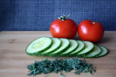Tahtadaki salatalıklar ve domatesler. Metin için boşluk.