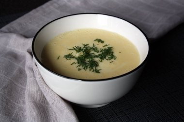 Beyaz kasede peynir çorbası.