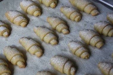 Fırında pişmiş çörekler üzerine pudra şekeri serpiştirilmiş..