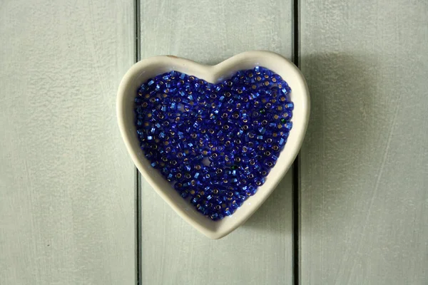 Perlas Azules Placa Forma Corazón Sobre Fondo Madera —  Fotos de Stock