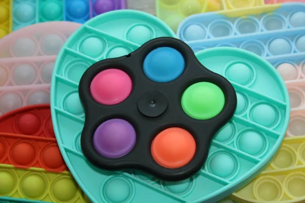 Renkli duyusal bir oyuncak onu itiyor. Çocukların silikon oyuncakları antistrese neden olur.