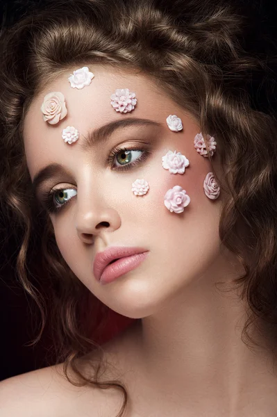 Koyu arka plan üzerinde romantik çıplak genç güzel kız beyaz çiçekli yüzünde ve yumuşak bukleler.