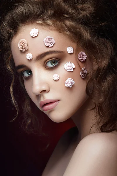 Koyu arka plan üzerinde romantik çıplak genç güzel kız beyaz çiçekli yüzünde ve yumuşak bukleler.