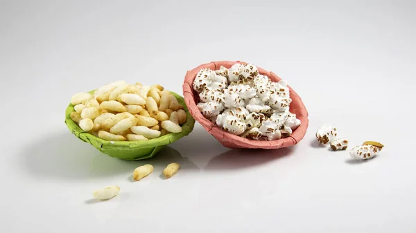 puffed rice and popped rice in pink paper thonga packet on white background studio shoot. local name in Bangladesh Muri and Khoi. traditional folk food among Bengal\'s.