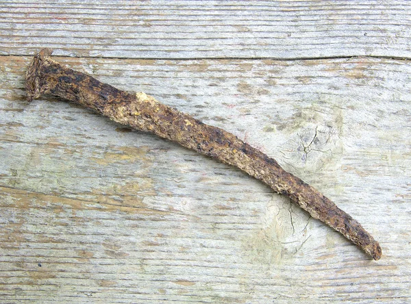 Old, big and rusty nail isolated on wood — Stock Photo, Image