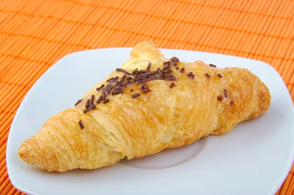 Croissant med choklad på trä bakgrund. Frukost. — Stockfoto