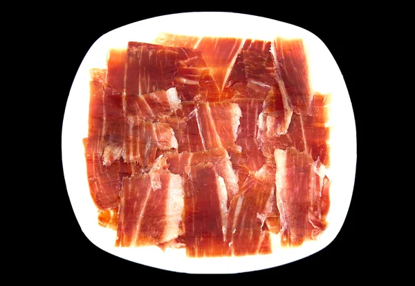 Plate of spanish serrano ham on black background. — Stock Photo, Image