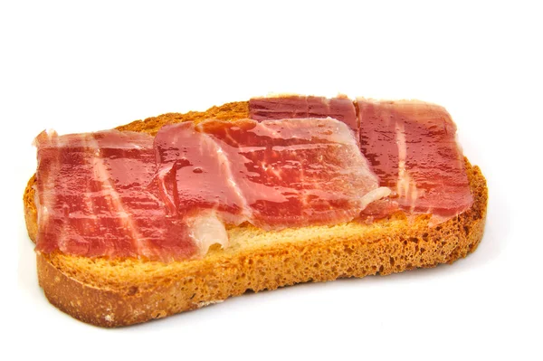 Spanish serrano ham on bread slice. White background. Tapa. — Stock Photo, Image