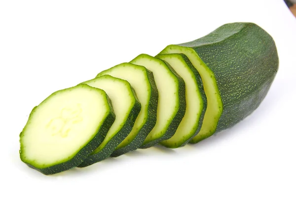 Halve courgette met sommige segmenten op witte achtergrond. — Stockfoto