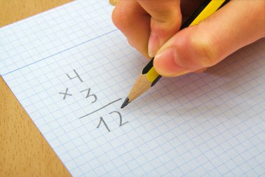 Closeup matematik yapıyor bir çocuğun ellerinde. Çarpın. Okul kavramı.