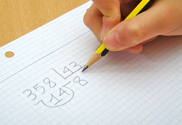 Närbild på händerna på barn gör matematik. Division. Skolan koncept. — Stockfoto