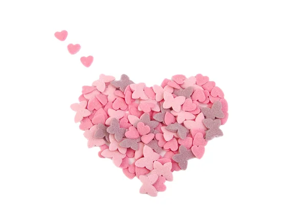 Şeker kalpler ile oluşan kalp şekli ve beyaz arka plan üzerinde izole kelebekler. Aşk kavramı. Sevgililer günü kavramı. — Stok fotoğraf