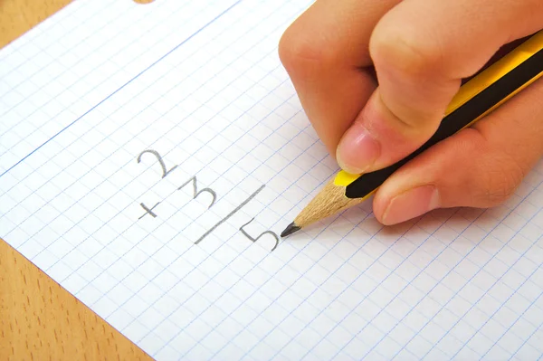 Hand om ett barn att göra en summa. Math. Skolan koncept. — Stockfoto