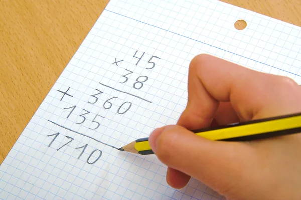 Niño haciendo una multiplicación matemática en la escuela . — Foto de Stock