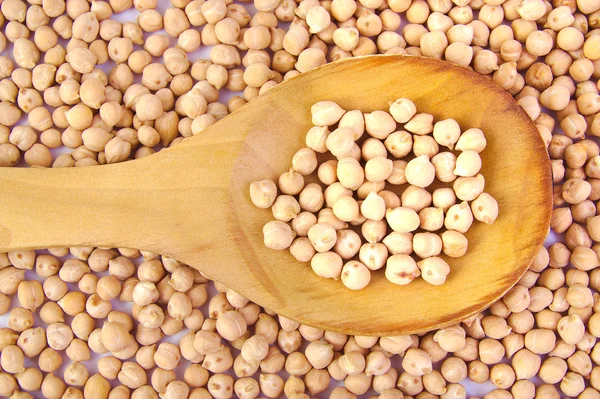 나무로 되는 숟가락에 생 쌀된 chickpeas — 스톡 사진