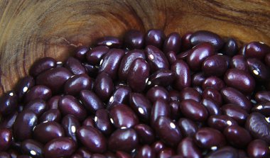 Uncoocked kırmızı fasulye bir zeytin ahşap kase. Gernika fasulye.