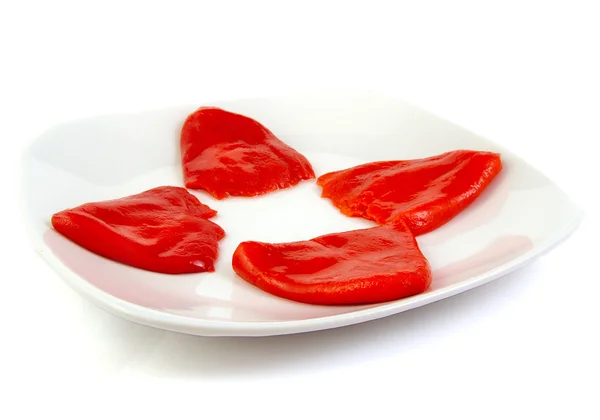 Roasted red peppers in olive oil on a white dish — Stock Photo, Image
