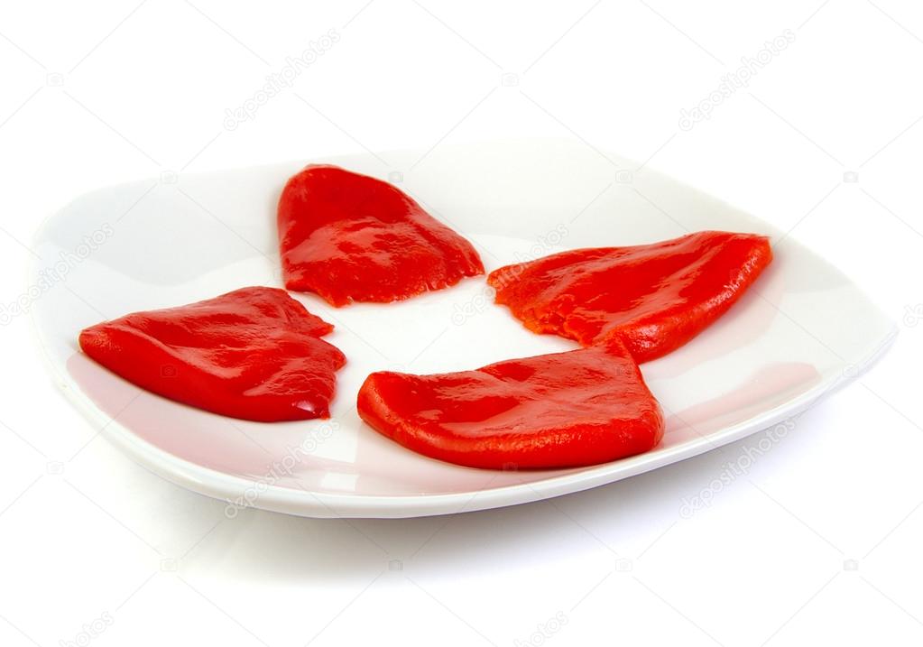 Roasted red peppers in olive oil on a white dish