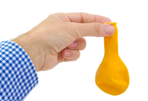 Man hand holding a yellow deflated balloon on white background — Stock Photo, Image