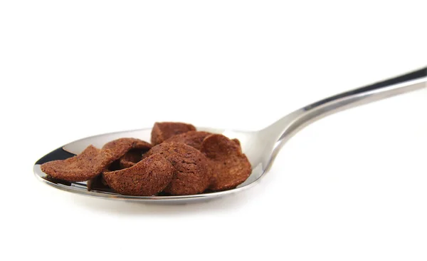 Cereales de chocolate sobre cuchara de metal, fondo blanco — Foto de Stock