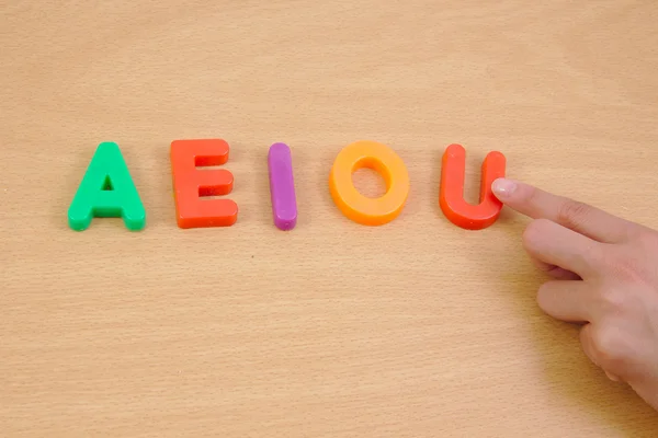 Letras a e i o u y mano de niño. Concepto escolar — Foto de Stock