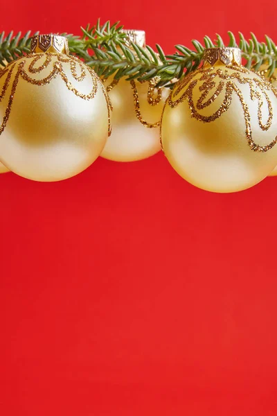 लाल पृष्ठभूमि पर ग्रीटिंग कार्ड के लिए क्रिसमस गोल्डन खिलौने — स्टॉक फ़ोटो, इमेज