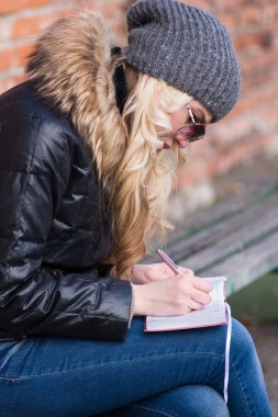 Genç kadın notlar alır.