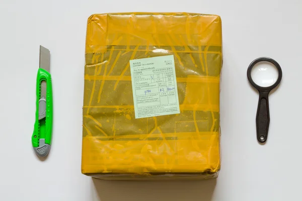 Unboxing gele perceel uit China. — Stockfoto