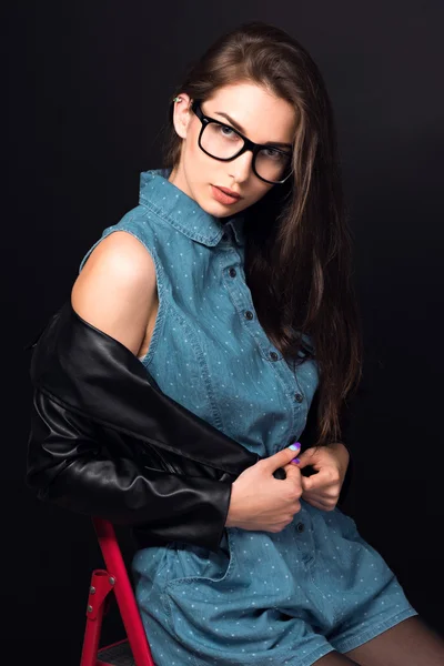 Hermosa joven en gafas sobre un fondo negro —  Fotos de Stock