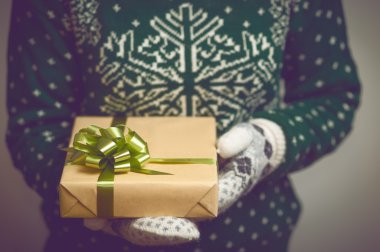 Kız ellerini Noel hediyesi tutar