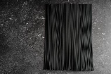 Koyu arkaplanda siyah çiğ erişte.