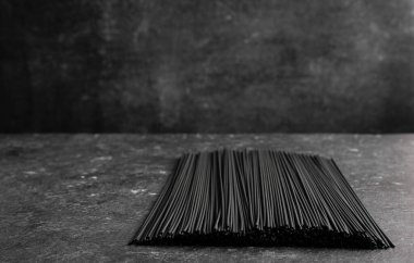 Koyu arkaplanda siyah çiğ erişte.