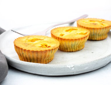 Gri keten peçeteyle el yapımı ve krom çatallı gri arka planı olan gri seramik tabakta küçük yumurta ısırmalı hamur tatlısı çörekleri. Parmak yemeği ve mini yemek konsepti. Model yap. Boşluğu kopyala