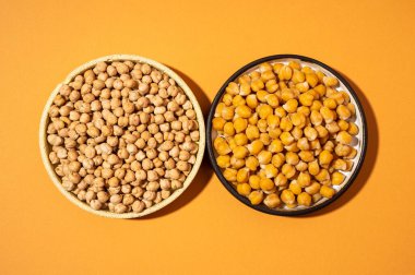 Bej turuncu arka planda izole edilmiş küçük sarı seramik tabakta nohut. Vejetaryen yemeği. Kapalı tabakta - konsept sağlıklı vegan protein organik gıda yemeği