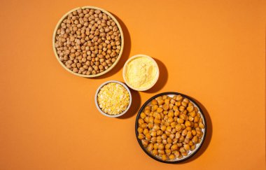 Turuncu arka planda izole edilmiş küçük sarı seramik tabakta nohut. Vejetaryen yemeği. Moda minimalizmi. Kapalı tabakta - konsept sağlıklı vegan protein organik gıda yemeği