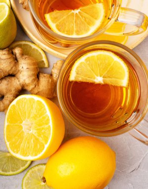 Gri arka planda zencefil, limon ve bal vitaminli sıcak bitki çayı. Alternatif tıp kavramını ele alalım. Soğuk algınlığı ve grip için doğal ev yapımı ilaç. Bağışıklık sistemini destekleyin. Refah ve Sağlık