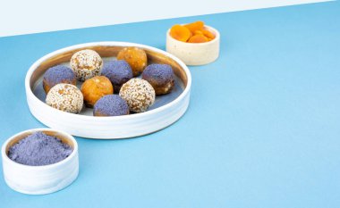 Ev yapımı mavi kibrit çöpü bezelye tozu enerji topları seramik bir kasede arka planda, sağlıklı tatlılar. Vejetaryen diyeti kavramının tatlı beyni sürdürülebilir gıdadır. Boşluğu kopyala