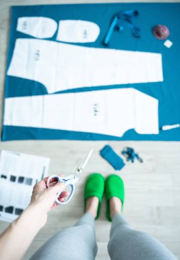 Evde dikiş deseni olan genç bir kadın çalışıyor. El işi hobisi kavramı. Akıl sağlığı ve stresi azaltma. Sürdürülebilir moda. Yaşam tarzı. Dijital detoks. Güzel anlar. İyilik