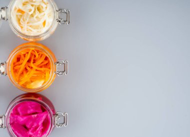 Ev yapımı lahana turşusu, kırmızı lahana ve cam kavanozlarda Kore havucu, gri arka plan. Probiyotik gıda kavramı, mide sağlığı için destek. Adaptojenler. Süper yemek, Top view. Boşluğu kopyala