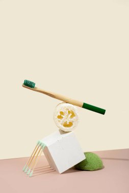 Modern natürmort. Dengeleniyor. İzometrik çapraz projeksiyon. Geometrik beton beyaz şekiller, ayaklıklar ve podyumlar. Sıfır atık, pastel pembe ve fildişi arka plan. Çevre dostu, sürdürülebilir yaşam tarzı