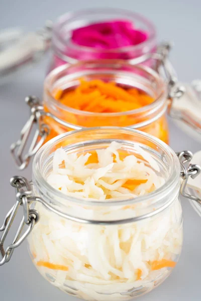 stock image Homemade village fermented sauerkrauts, red cabbage and korean carrot in glass jars, gray background. Concept probiotics food, Supplement for gut health . Adaptogens. Superfood, Close up.