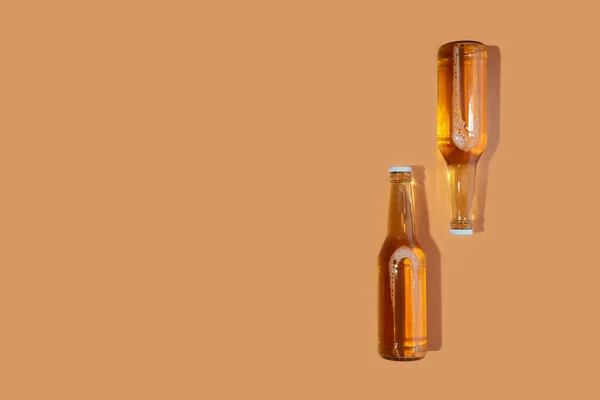 A bottles of craft beer on beige background. International beer day or Octoberfest concepts.Resting and Drinking beer after a hard working day in the home.Minimalistic colors on a photo.Copy space