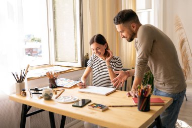 Sanat okulunda yüksek lisans dersi. Kız yağlı boyalarla bir portre çiziyor ve öğretmen infaz sürecindeki çalışmalar hakkında yorum yapıyor. Yetişkinler için çizim dersleri.