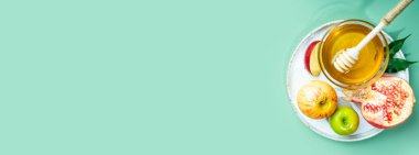 Nane yeşili arka planda bal, elma ve nar. Yahudi Yeni Yılı 'nı kutla Rosh Hashanah. Geleneksel sembollerin yaratıcı düzeni. Yukarıdan bak. Düz yatıyordu. Uzayı kopyala Shana Tova.