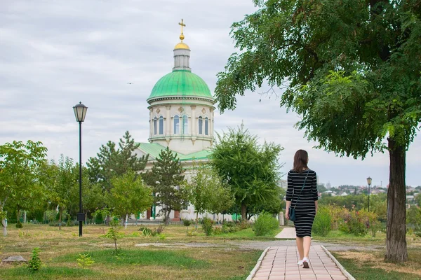 Girl walks in the church's park — Stok fotoğraf