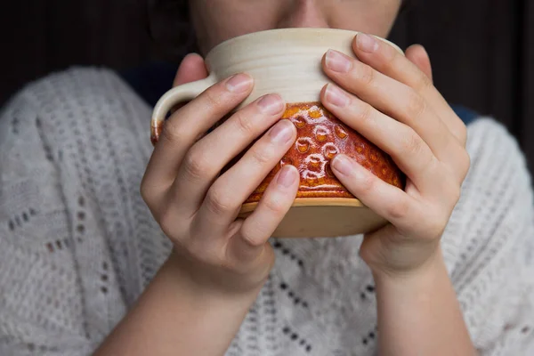 Young woman holding mug of tea. Autumn or winter moody weekend. Lazy day, quarantine, stay home, cosy scene, hygge concept.